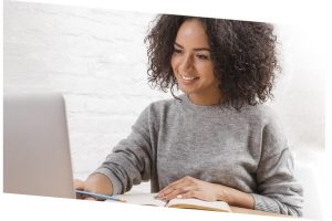 woman working with a laptop and taking notes